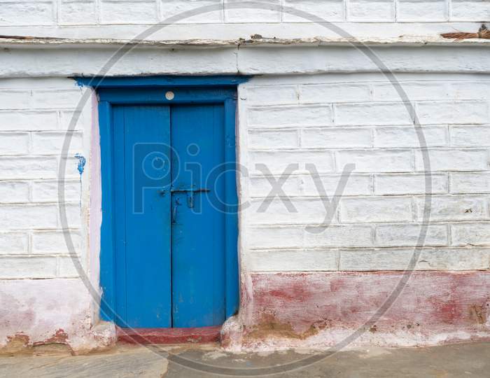 A Blue Door On A White Wall With Square Shapes On It.