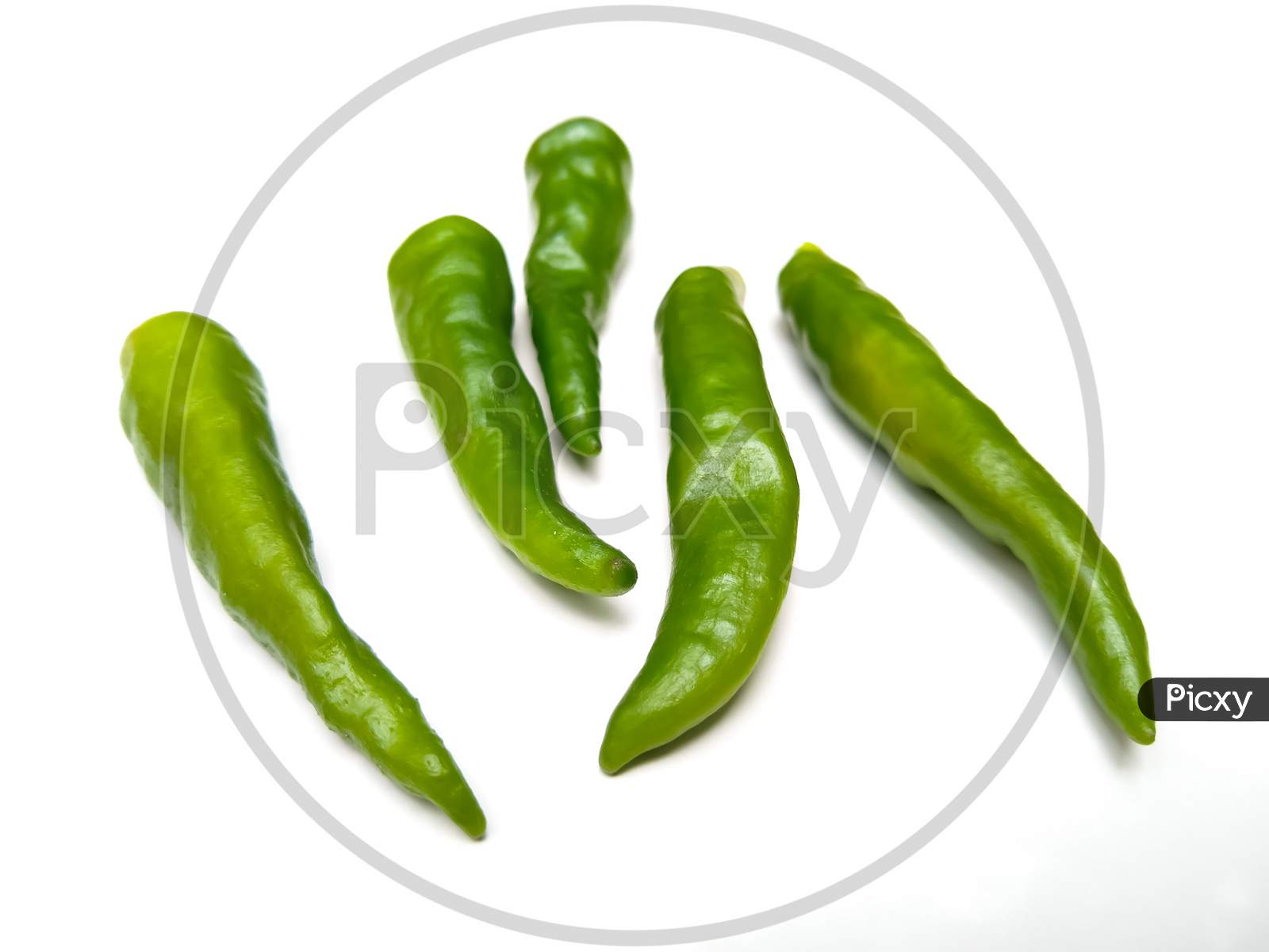 Green chilli peppers on white background