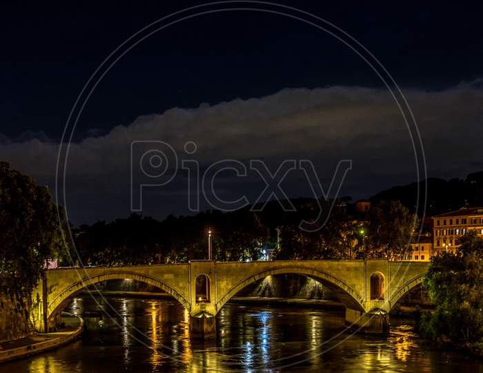 Tiber River Flowing Under A Bridge In Rome, Italy
