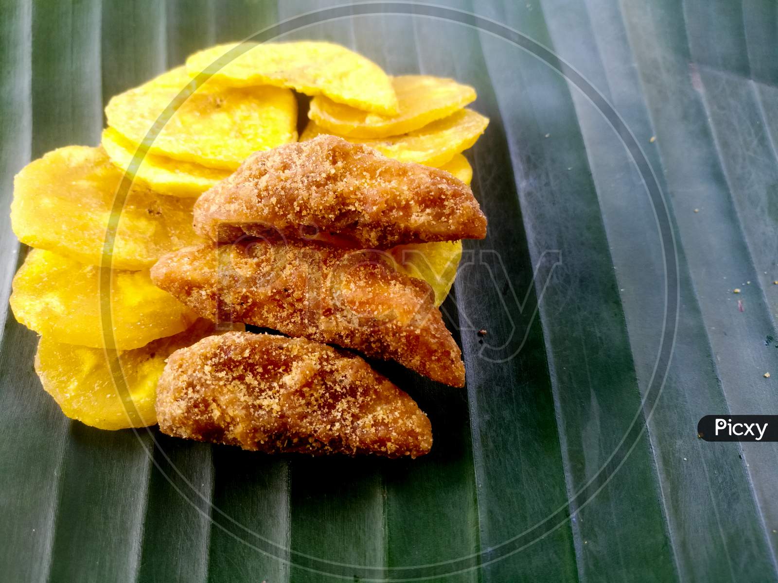 Banana Chips With Jaggery Coated Banana Chips On A Banana Leaf.