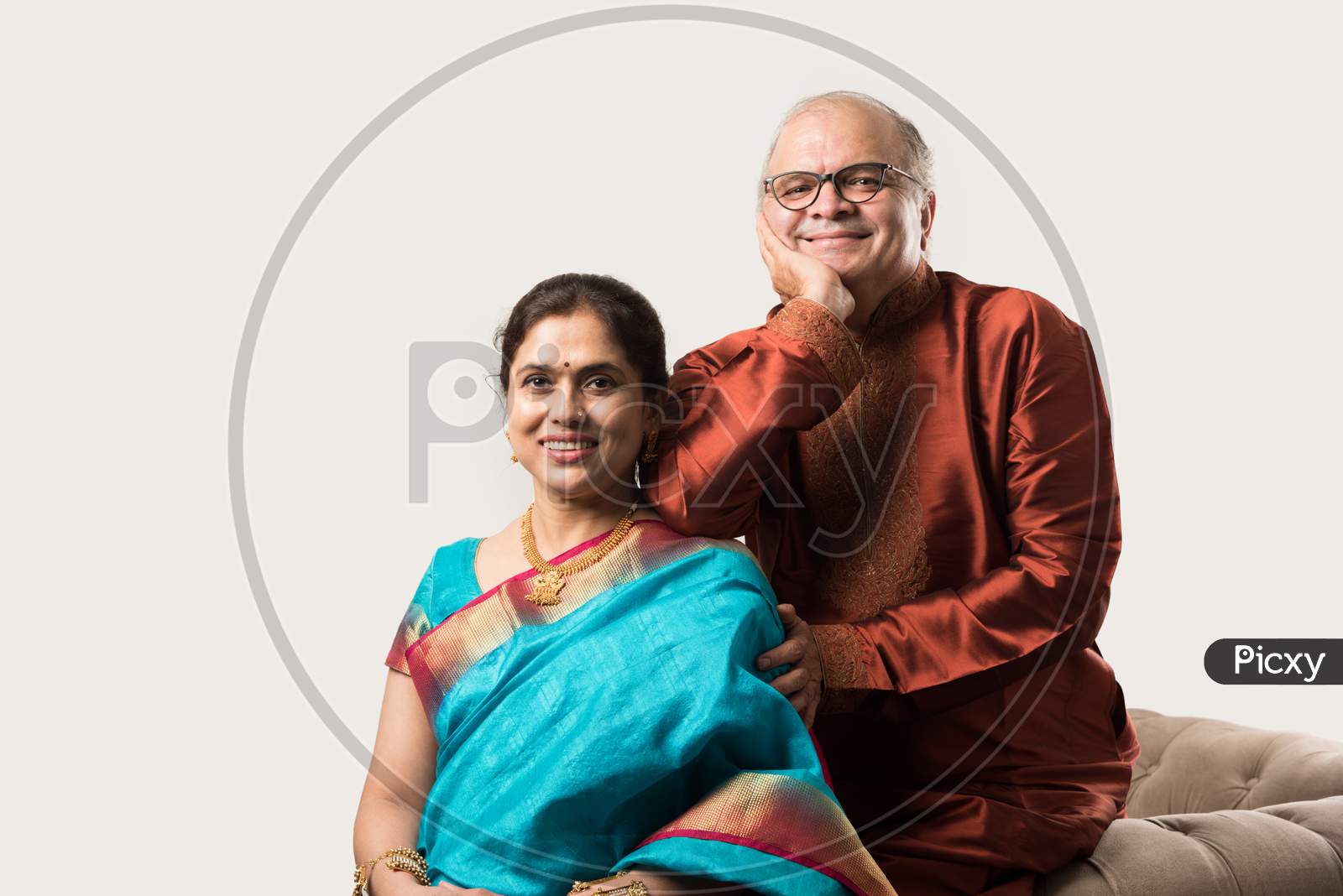 Portrait Of Happy Indian Old Couple Or Senior Adults In Traditional Ethnic Attire Or Party Wear