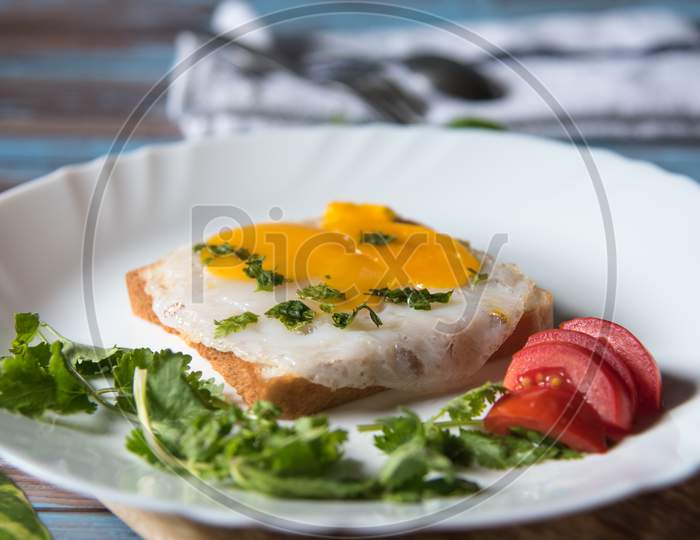 Fried egg with salad on bread with ingredients with use of selective focus and background blur