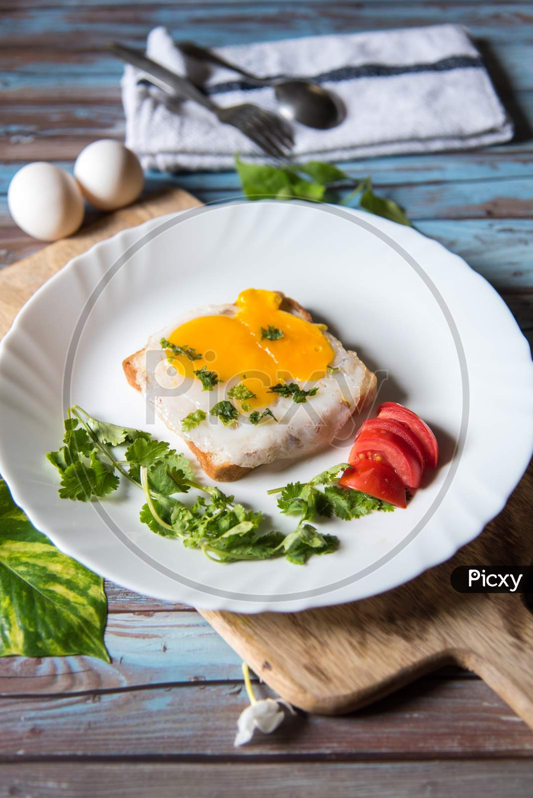 Fried eggs with toast, tomatoes and condiments with use of selective focus