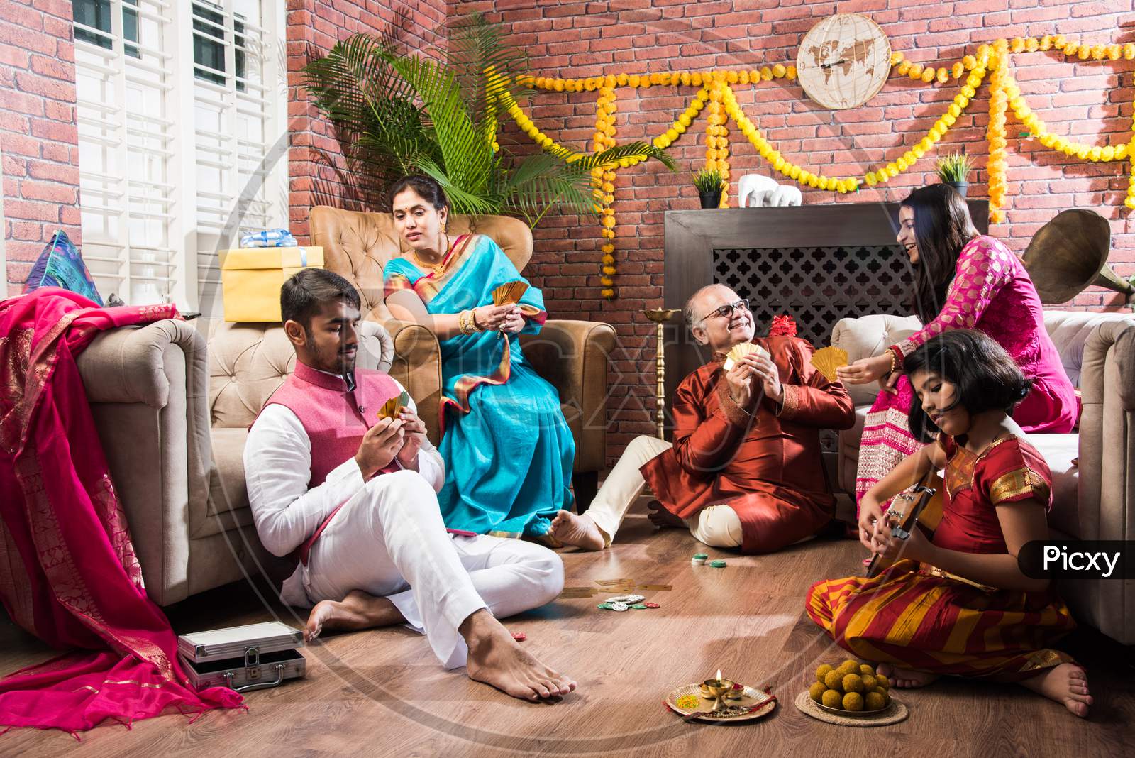 Indian Family Playing Three Cards Or Teen Patti In Diwali Or Deepavali Festival At Home