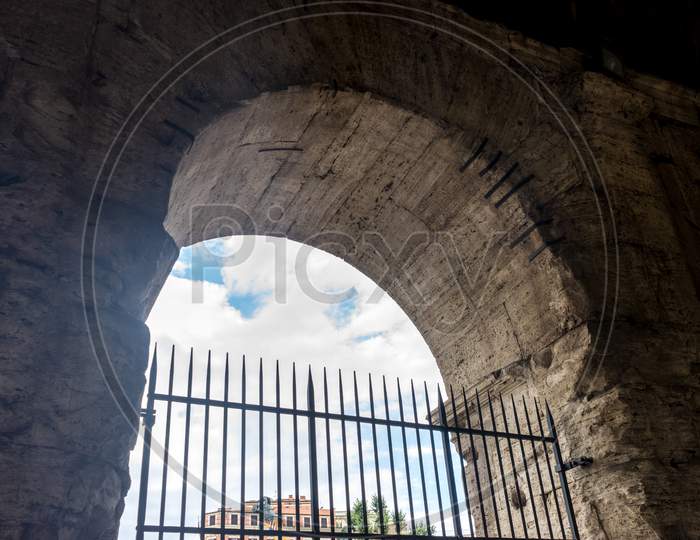 Rome, Italy - 23 June 2018: The Gated Arch Of The Passage At The Entrance Of The Roman Colosseum (Coliseum, Colosseo), Also Known As The Flavian Amphitheatre. Famous World Landmark. Scenic Urban Landscape.