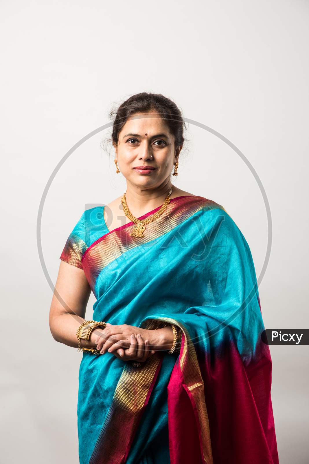 Portrait Of Mid Age Or Old Indian Asian Woman Or Lady In Traditional Saree Against White Background