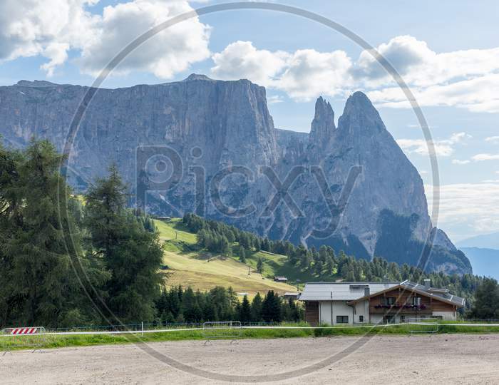 Alpe Di Siusi, Seiser Alm With Sassolungo Langkofel Dolomite, A Large Green Field With A Mountain In The Background