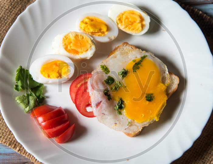 Vertical view of bread slice with poached egg and slices of boiled eggs