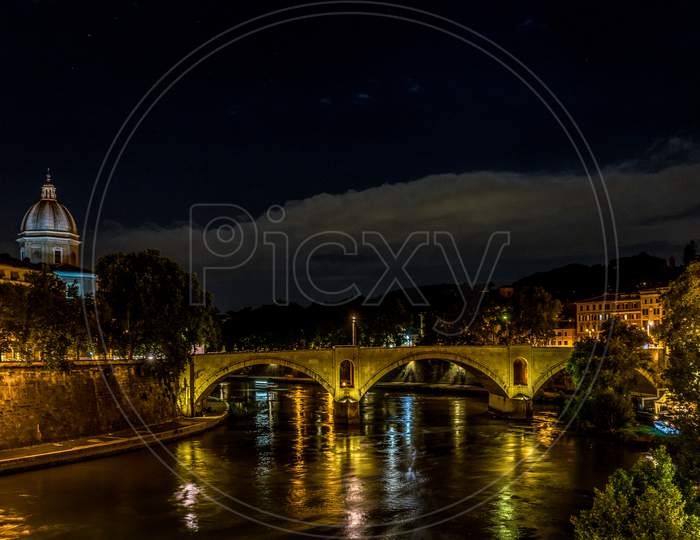 Tiber River Flowing Under A Bridge In Rome, Italy