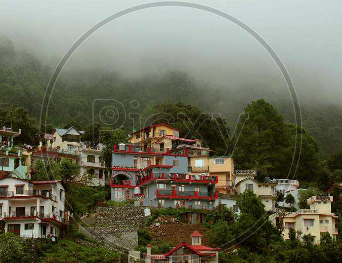 Mountain houses covered by fog and low clouds.