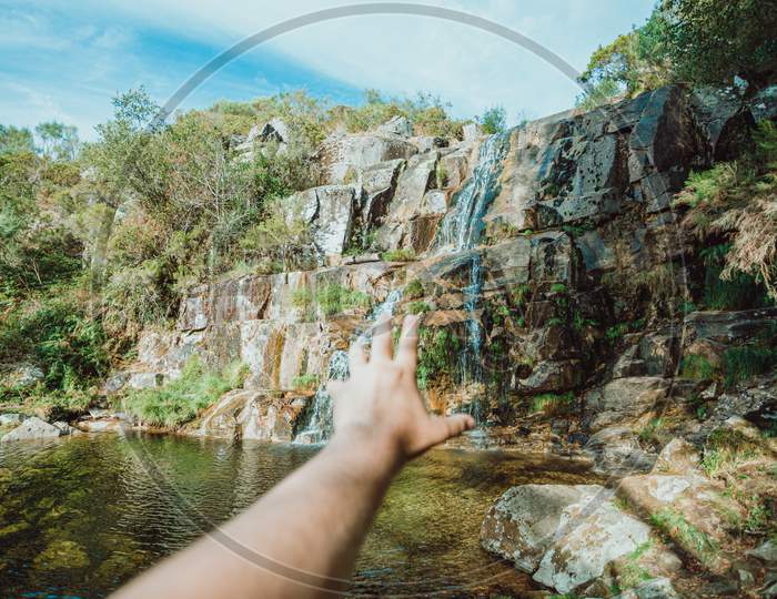 Out Of Focus Hand Trying To Reach A Waterfall In A Inspirational Image
