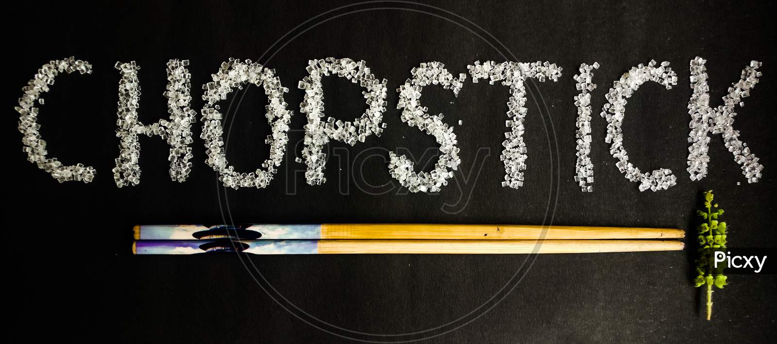 Chopsticks on black background. Written with sugar