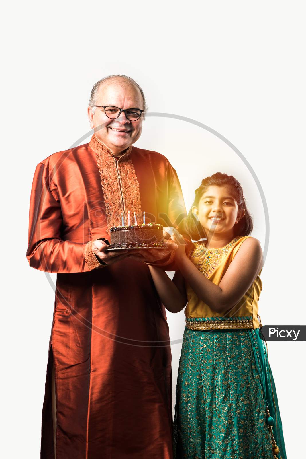 Indian Grandfather And Granddaughter Celebrating Birthday Together With Chocolate Cake