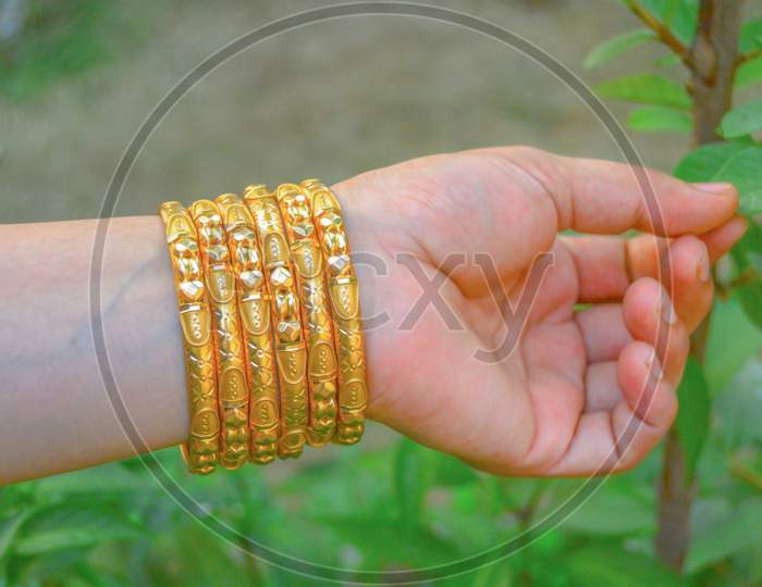 Beautiful gold bangles on white hand