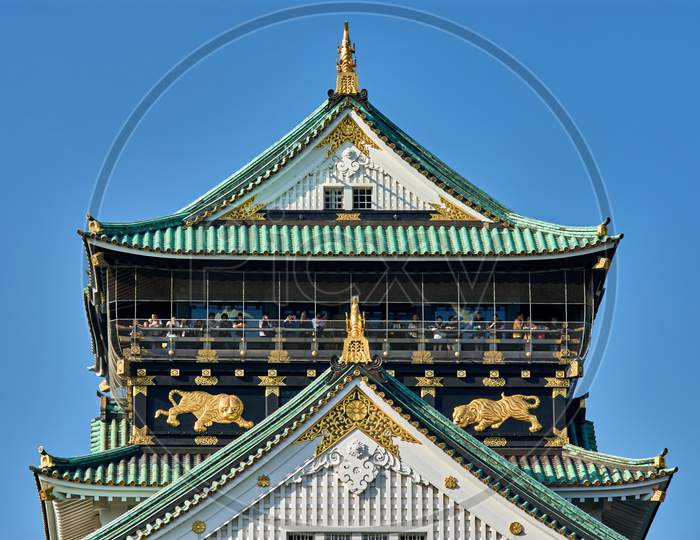 Tourists Visiting The Main Keep Of Osaka Castle, Symbol Of Osaka And Japan