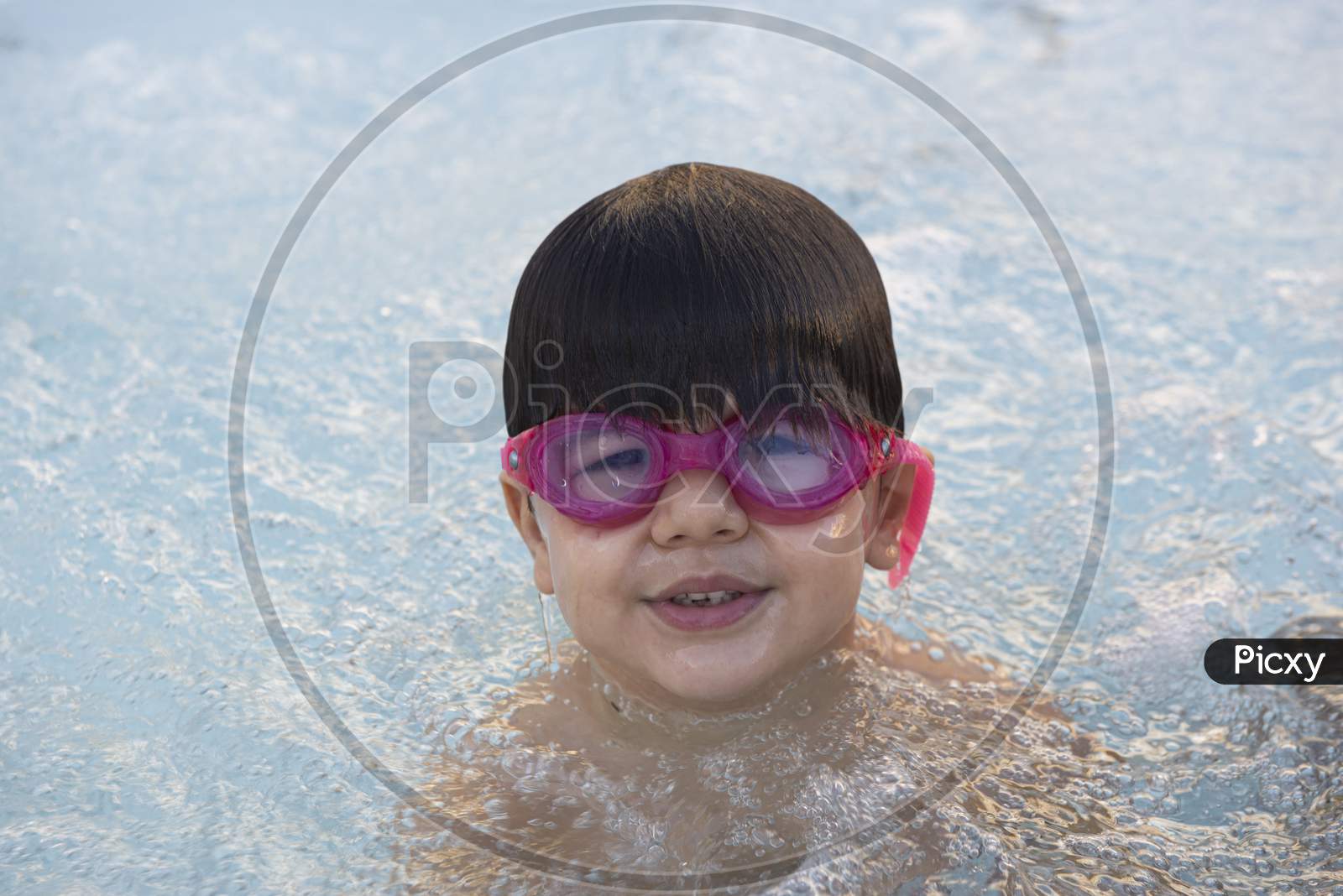 Boy With Pink Swimming Goggles Having Fun In A Hydromassage Bath.