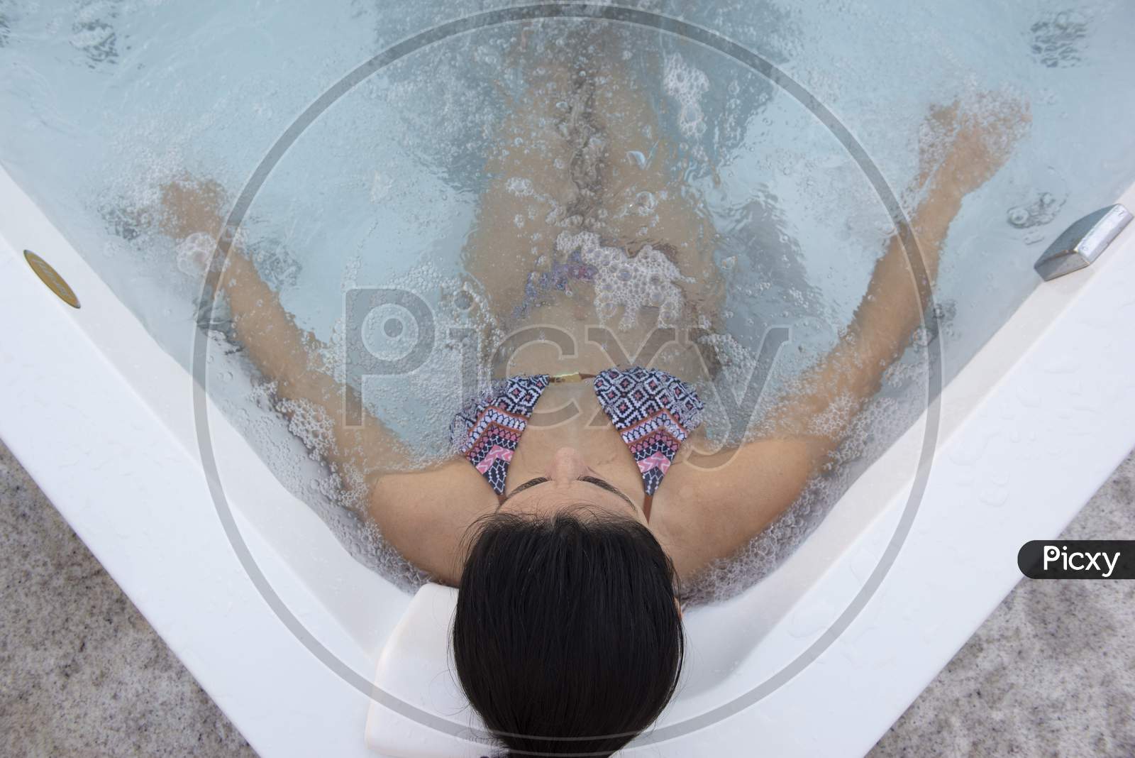 Top View Of Beautiful Bikini Woman In A Hydromassage Bath, , In A Bathing Suit. Concept: Spa Procedures, Body Massages, Spa Cream, Relax, Spa Water Treatments, Swimming Pool.