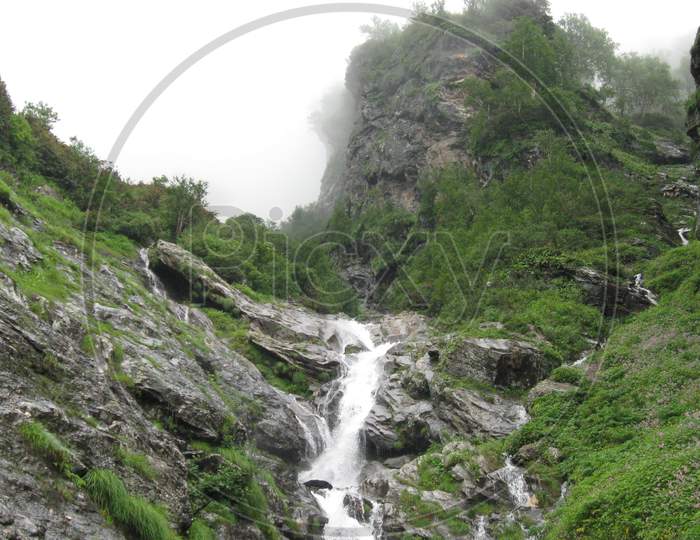 Narrow waterfall through rocky mountain surface