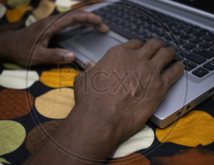Man Press Black Key On Keyboard In Gray Color Laptop.Close Up Laptop Keyboard With Touch Pad.Hand Writing Or Typing On Keyboard.Man Using A Laptop On Bed. Chatting Concept.