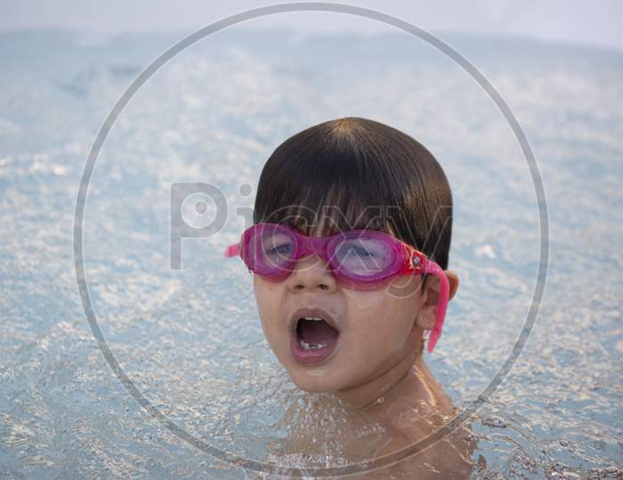 Boy With Pink Swimming Goggles Having Fun In A Hydromassage Bath.