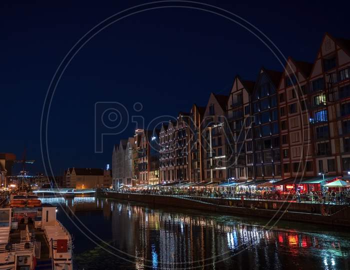 Gdansk, North Poland - August 13, 2020: Night Photograph Of Medieval Style Polish Architecture Over Motlawa River