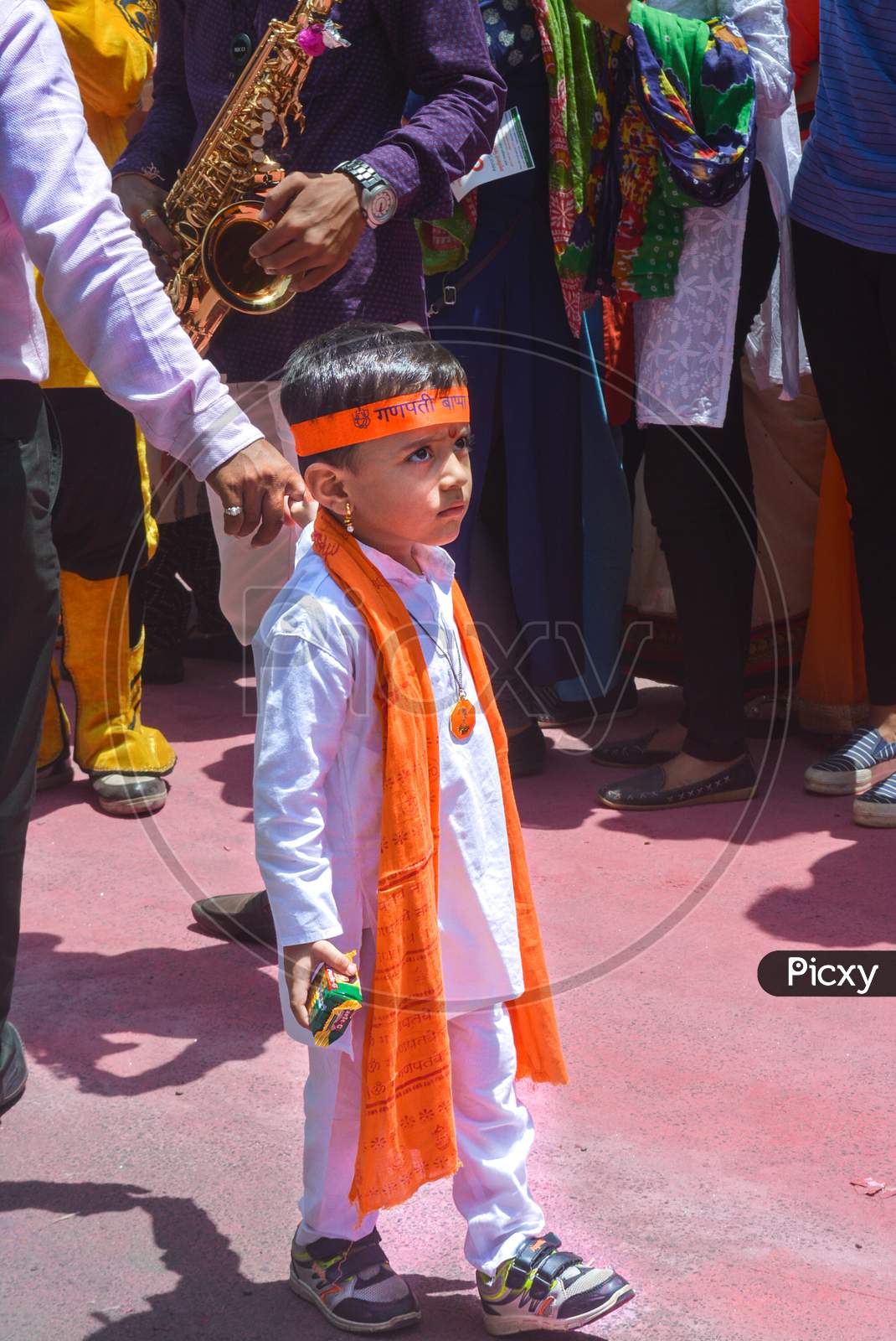 Pune, India - September 4, 2017: A Small Kid Wearing Traditional Clothes Holding His Father'S Hand Looking Confused On The Streets Of Pune During Ganpati Visarjan. A Kid Wearing Traditional Clothes.