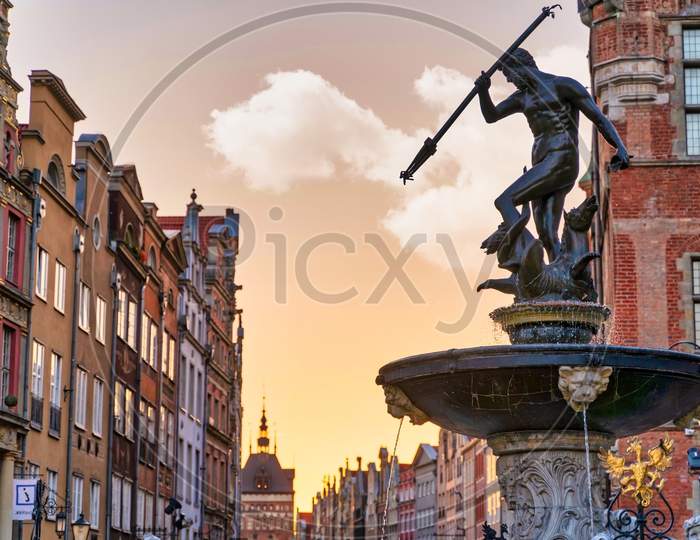 Gdansk, North Poland - August 15, 2020: Wide Angle Shot Of Famous Touristic Attraction Of Neptune'S Fountain Located At The City Center Main Square Of Old Town Against Dramatic Sky