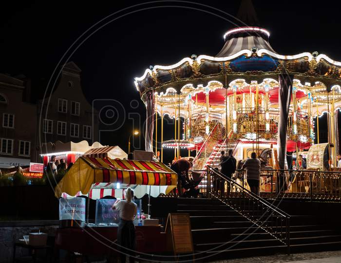 Gdansk, North Poland - August 13, 2020: Night Photography Of Illuminated Carousel Horse For Kids At City Center Old Town Over Motlawa River Near Baltic City