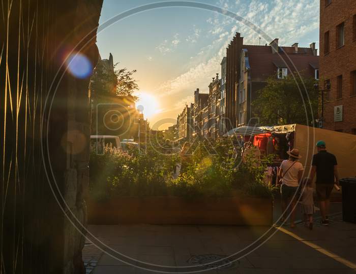 Gdansk, North Poland - August 13, 2020: A Family Of Father Mother And Daughter Walking Towards Sunset In Old Town Near Motlawa River During Covid Time