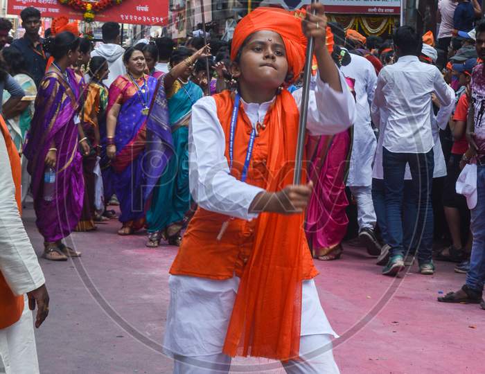 Pune, India - September 4, 2017: A Small Girl Looking Aggressive And Is Passionately Dancing With A Flag On The Occasion Of Ganpati Visarjan Festival / Anant Chaturdashi Festival Celebration In Pune.