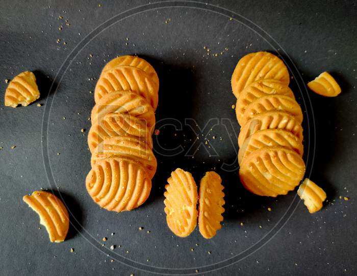 Stack Of Cashew Cookies Or Biscuits And Crushed Cookies Isolated On Black Background. Top View