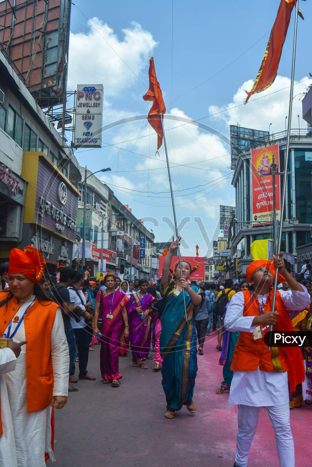 Pune, India - September 4, 2017: People Raising Orange Flags On The Occasion Of Ganpati Visarjan From Across India On The Streets Of Pune. Women And A Girl Happily Dancing With The Traditional Flags