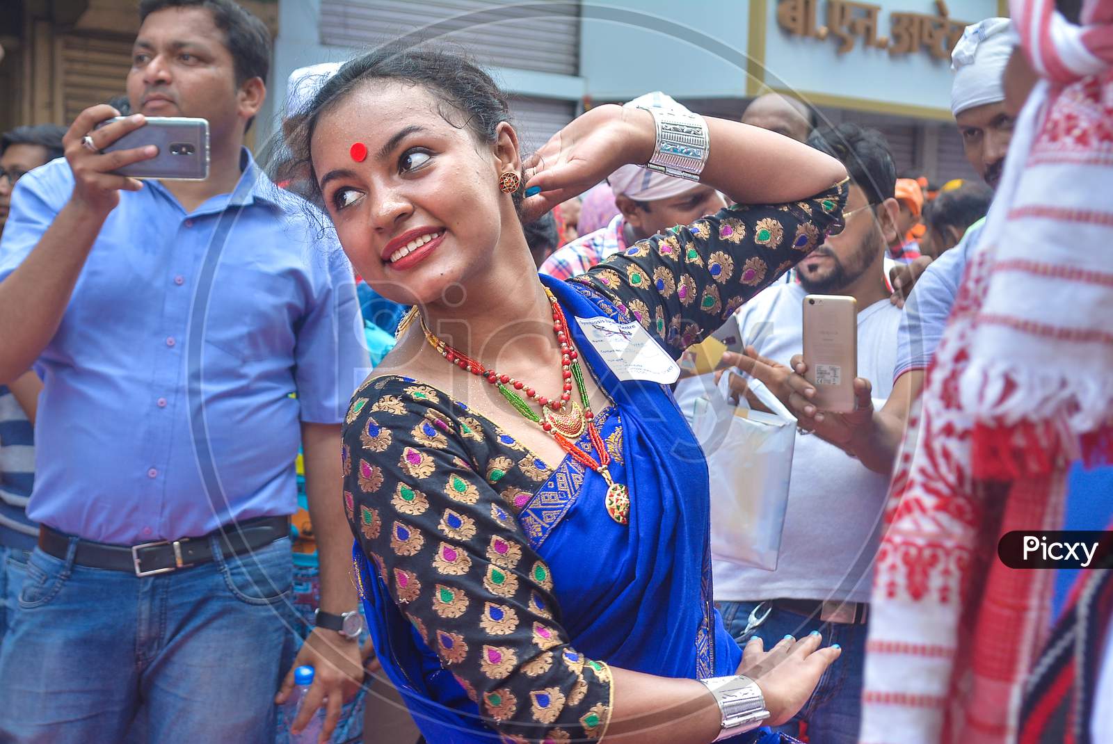 Pune, India - September 4, 2017: Assamese Women Wearing Traditional Saree And Jewellery Doing Folk Dance On The Crowded Streets Of Pune On The Occasion Of Ganpati Visarjan Festival.