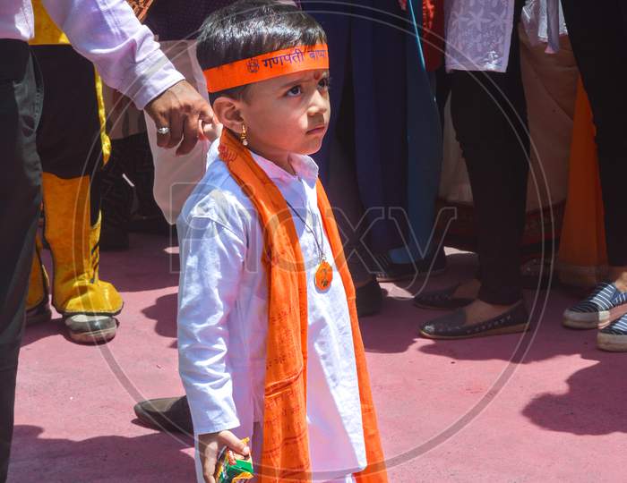 Pune, India - September 4, 2017: A Small Kid Wearing Traditional Clothes Holding His Father'S Hand Looking Confused On The Streets Of Pune During Ganpati Visarjan. A Kid Wearing Traditional Clothes.