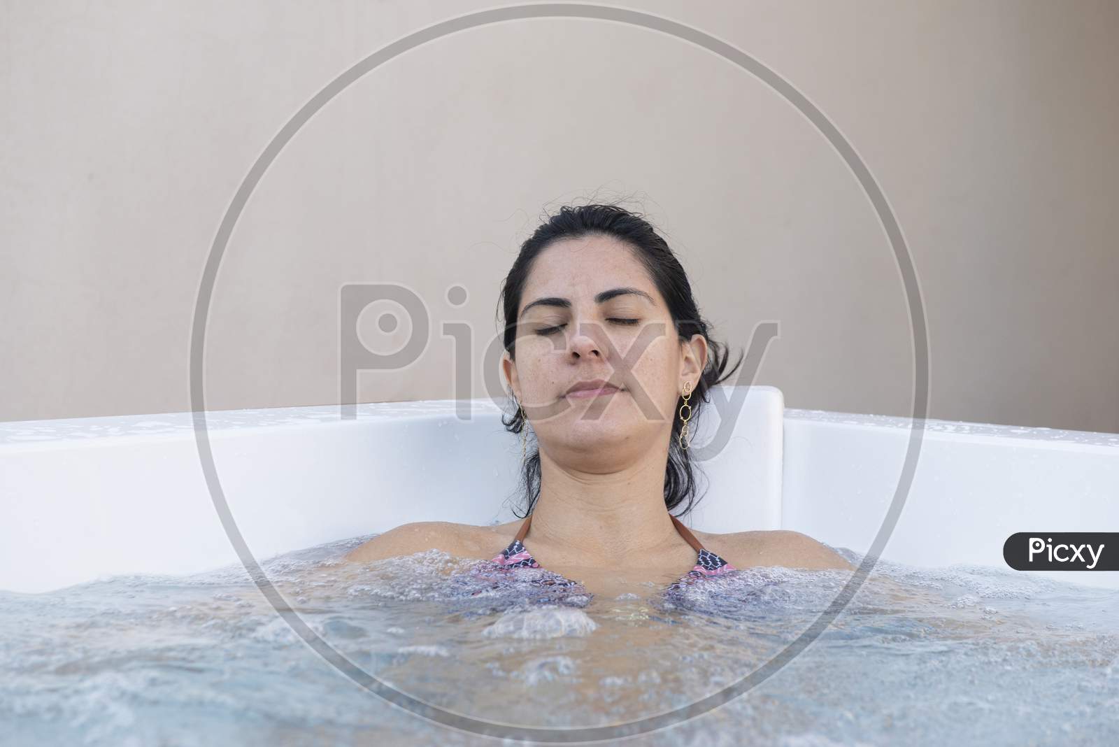 Side View Of Young Beautiful Woman Relaxing And Enjoying In A Hydromassage Bath.