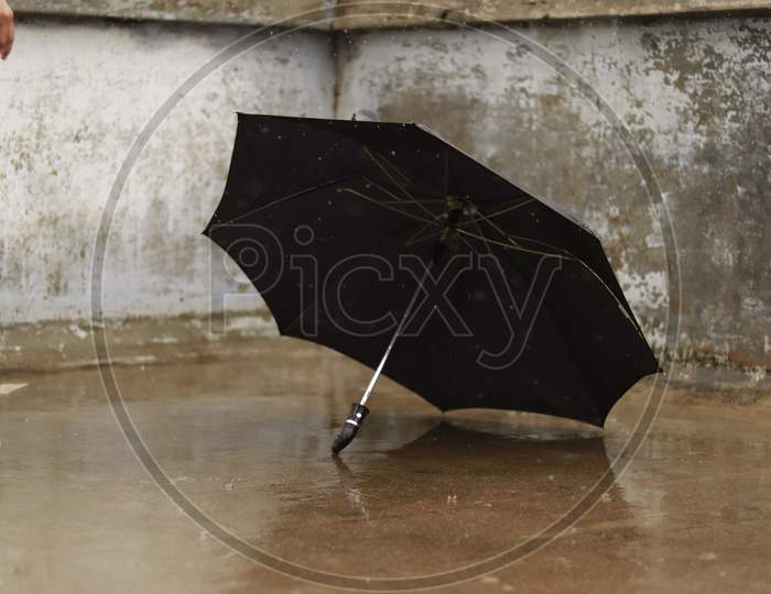 black umbrella fall on concrete floor