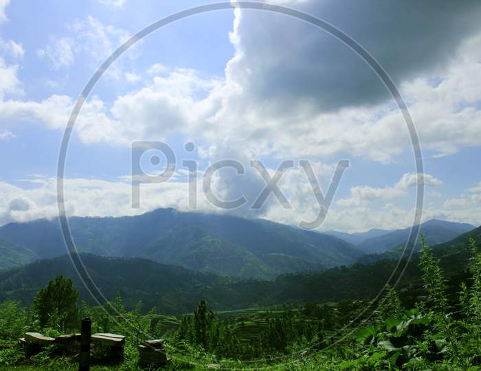 Beautiful landscape with mountains,forest and pines, blue sky & clouds.