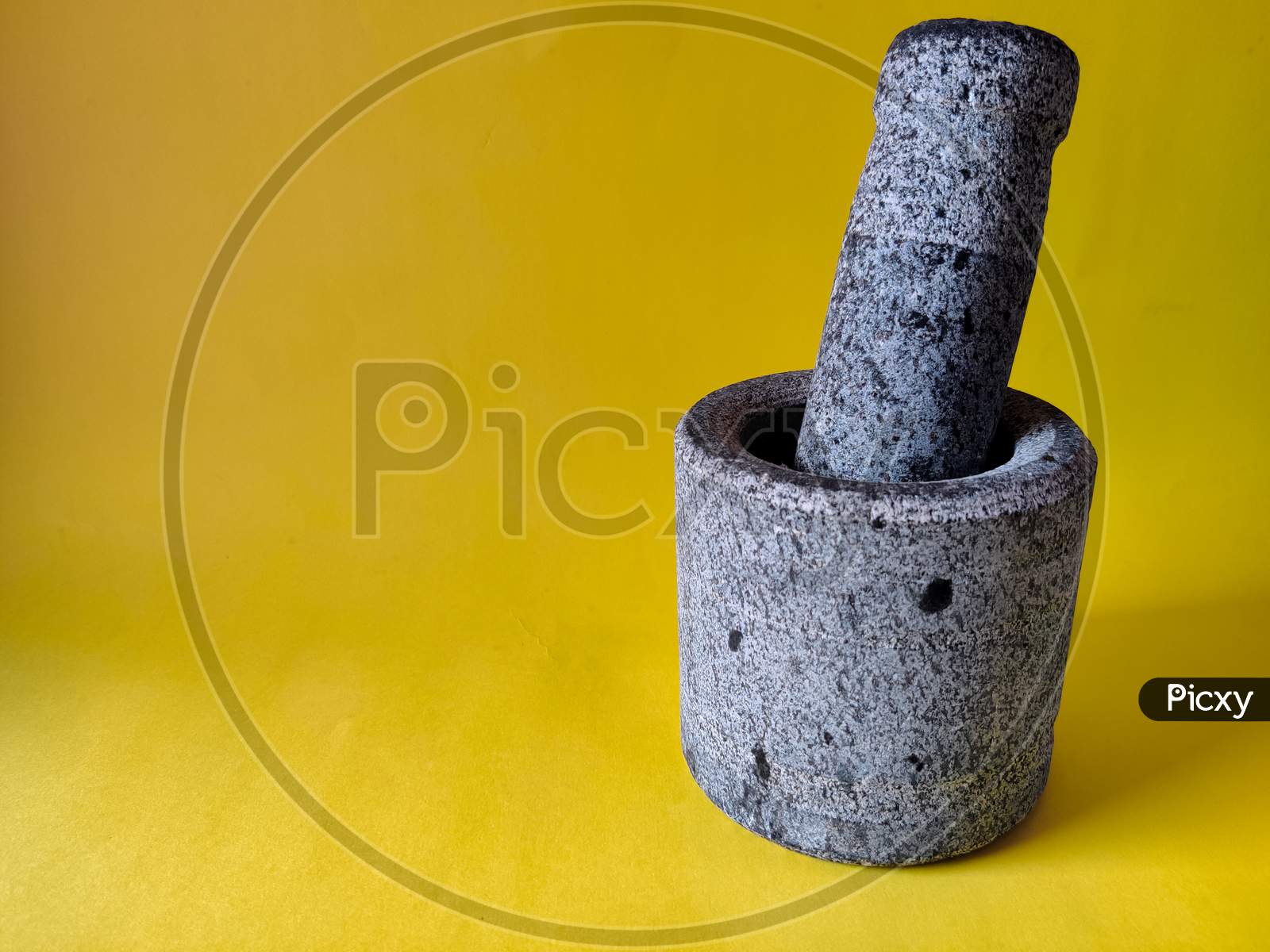 Mortar And Pestle Set Made Of Stone. Isolated On Yellow Background. Copy Space