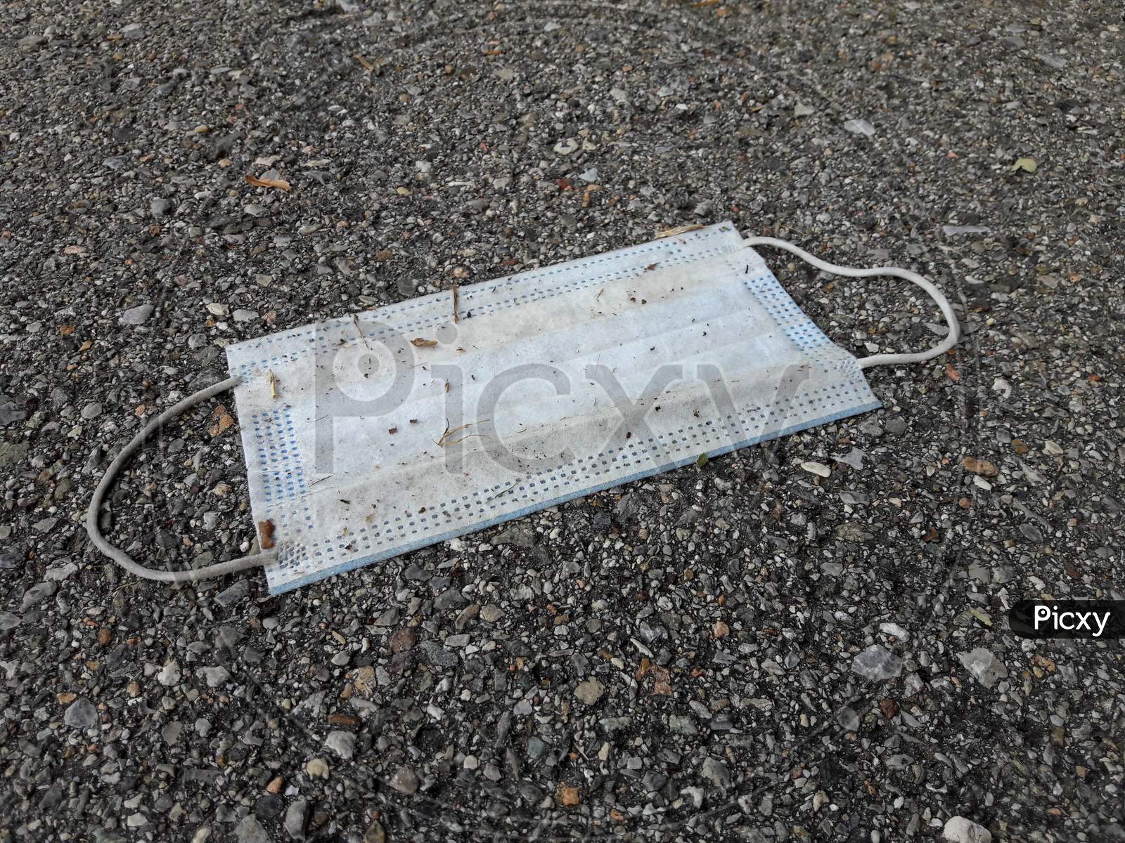 A Used Surgical Mask Dumped On Sidewalk