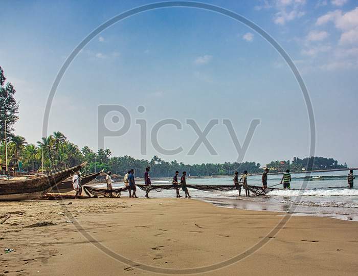 Malvan Sea beach with boat at early morning and fishermen fishing