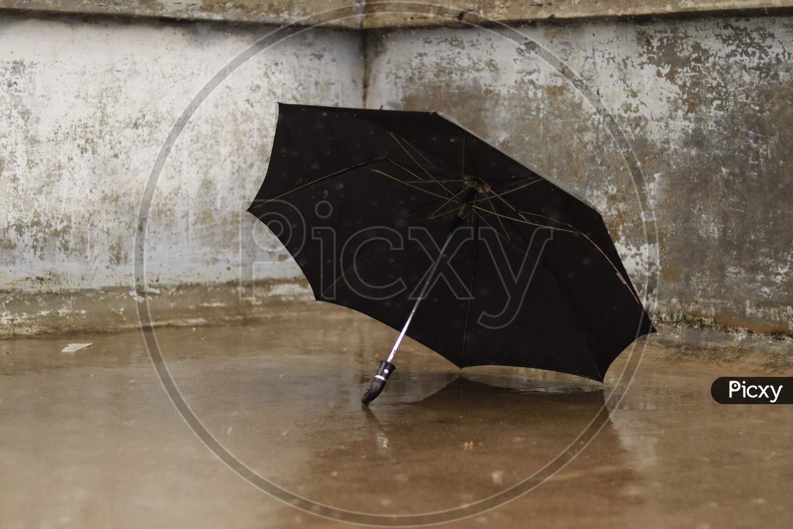 black umbrella fall on concrete floor