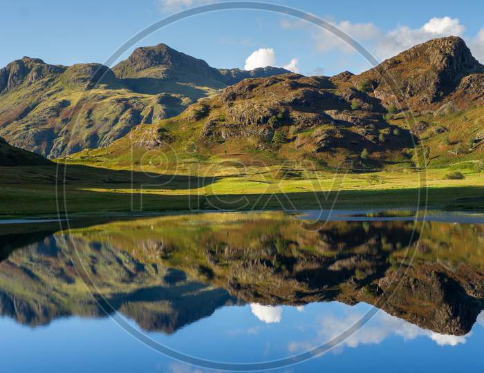 Reflections Of The Langdales In Blea Tarn In The English Lake District, Uk
