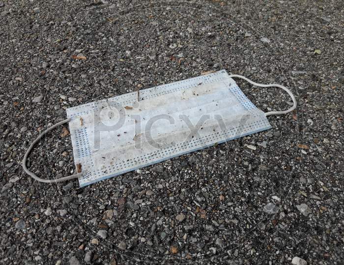 A Used Surgical Mask Dumped On Sidewalk