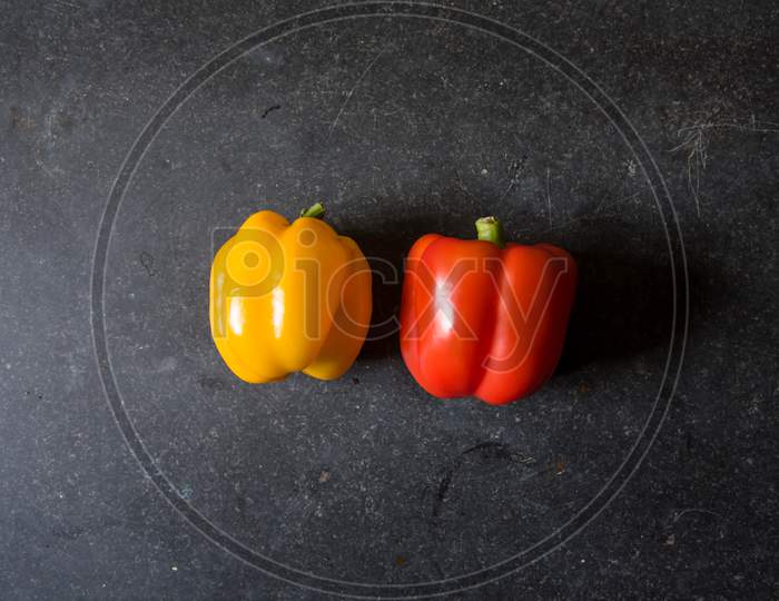 Red and yellow pepper on a black background
