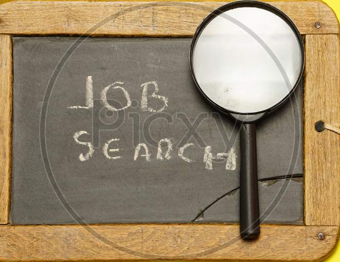 Top View Of Magnifying Glass On Blackboard With Job Search Message. Flat Lay