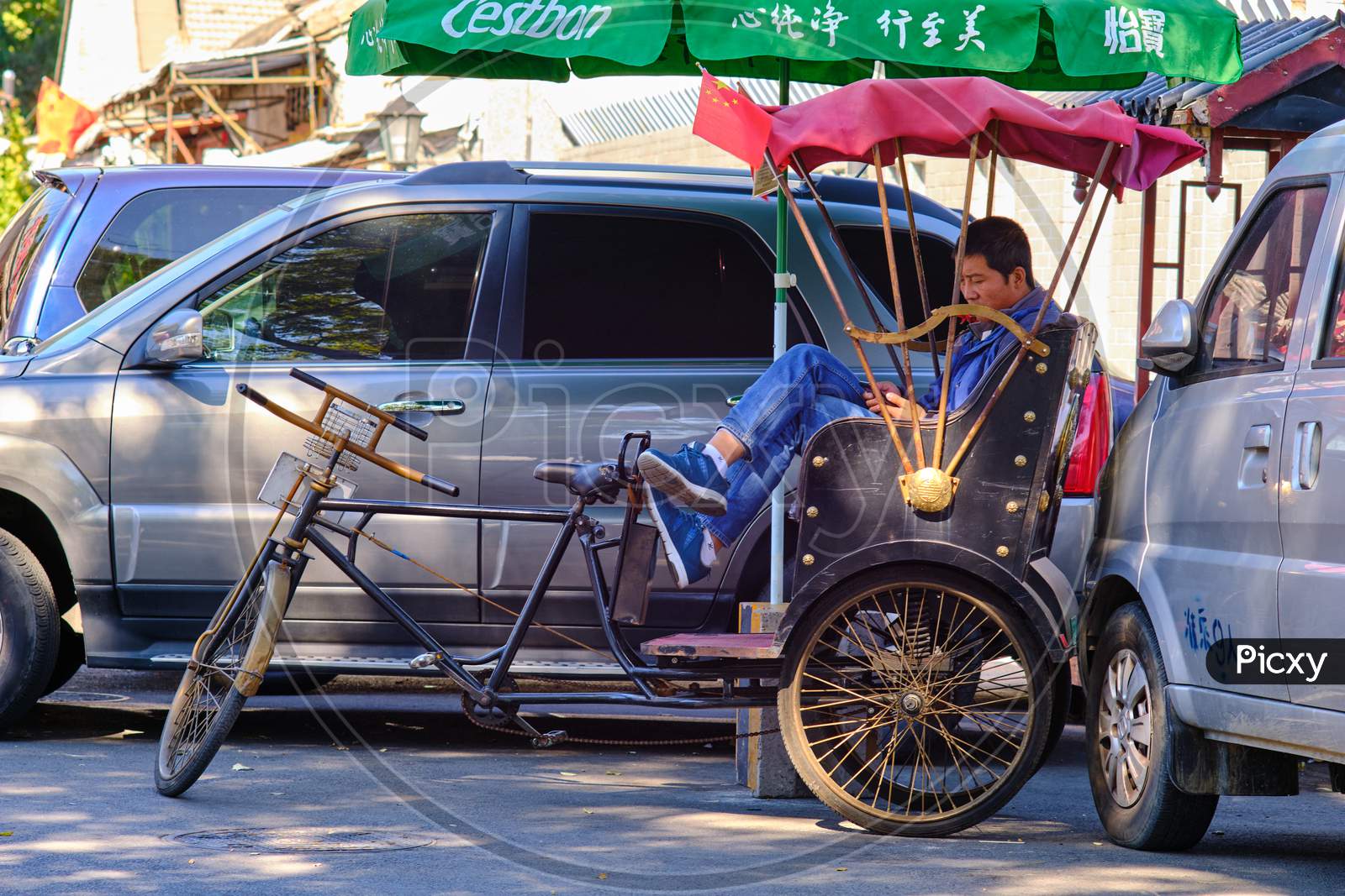 Tourist Bicycle Rickshaw Driver Taking A Break From Work In Beijing, China