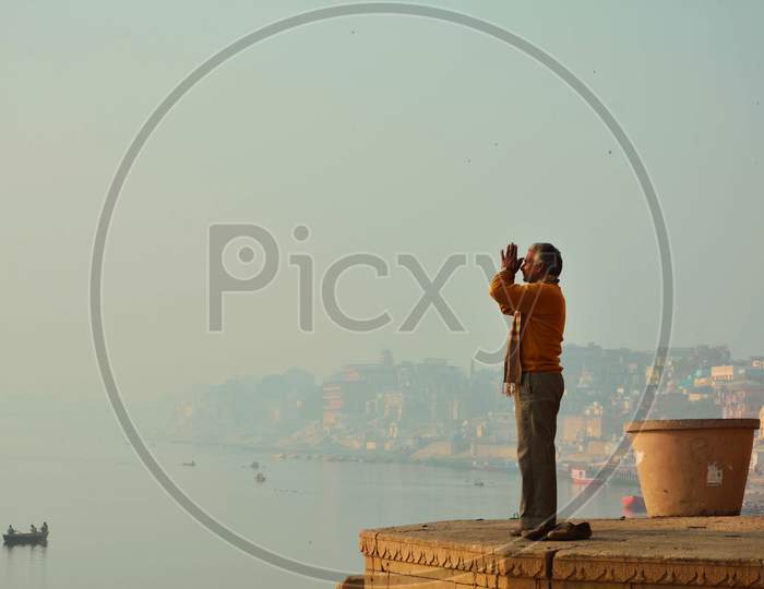 A devotee doing  Surya Namaskar on the bank of Ganges in Benras