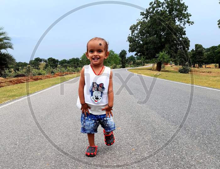 A cute baby girl walking in the Road