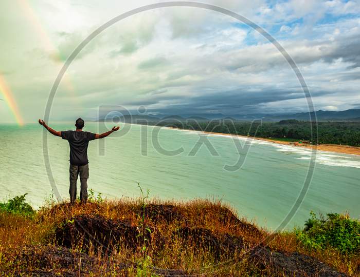 Man At Hilltop Enjoying Amazing Landscape Of Sea Shore