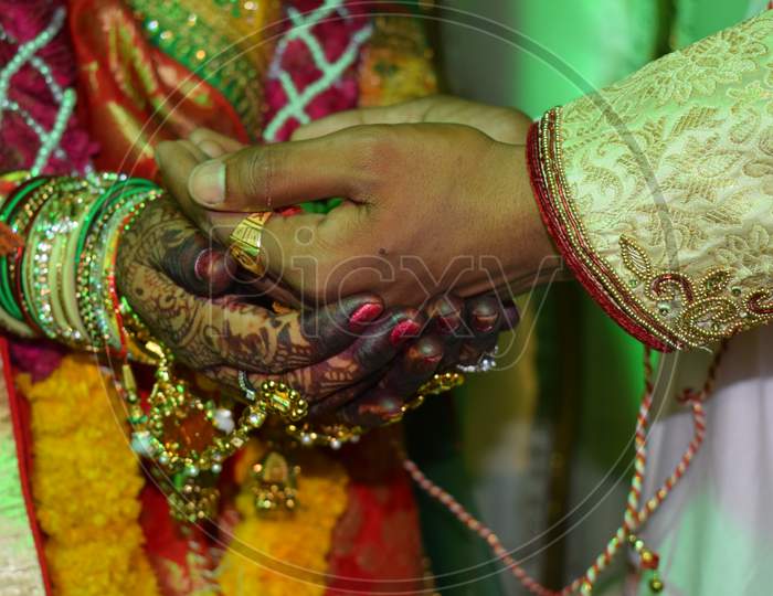 Beautiful Indian bride hand with mehandi design and jewelry .